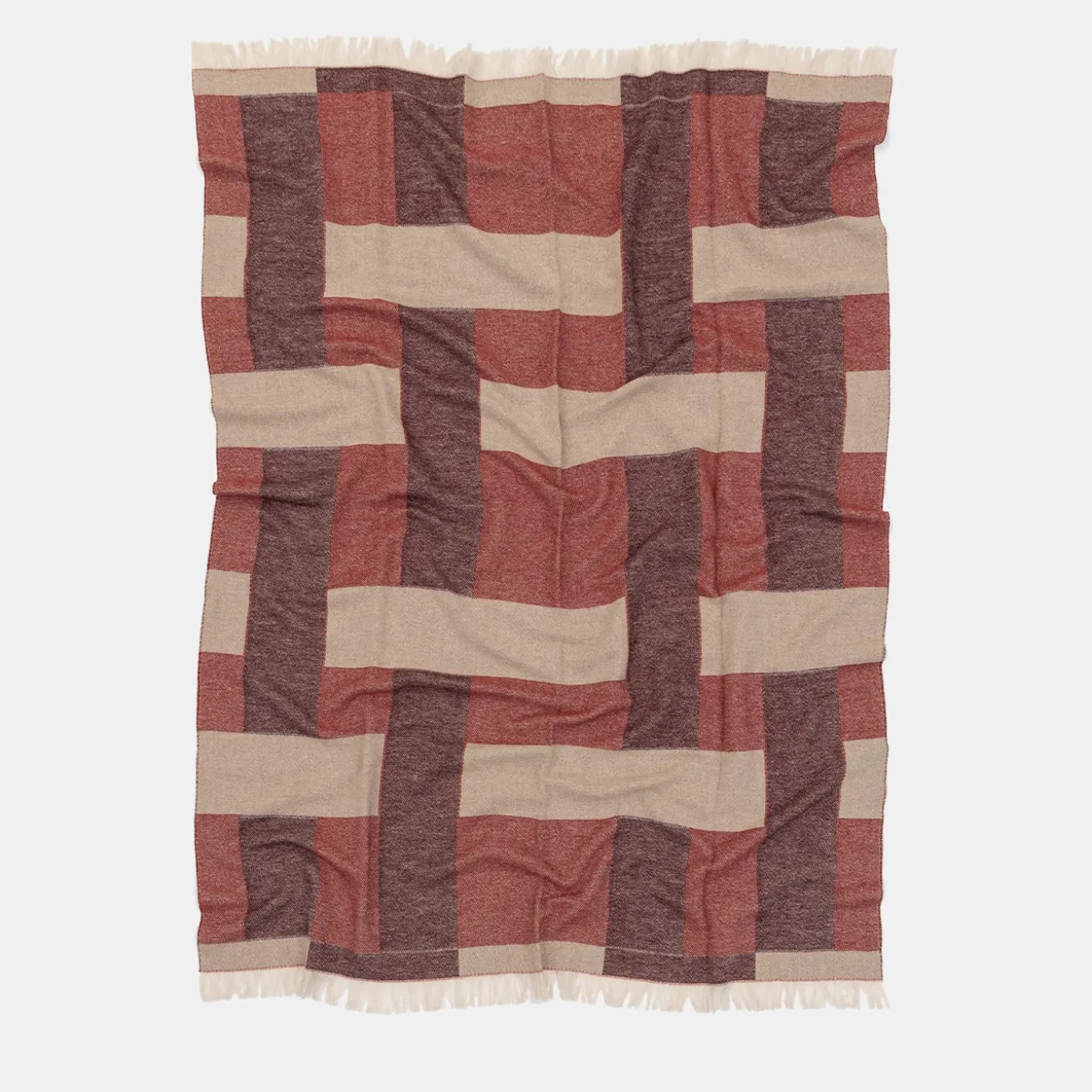 Coperta rossa con frange e motivi intrecciati