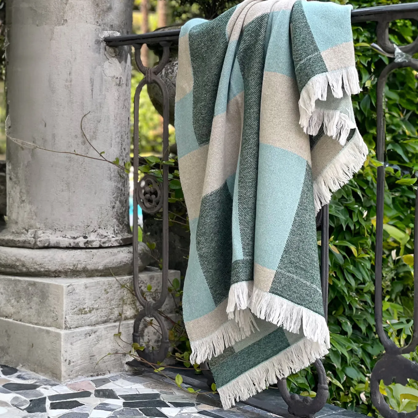 Coperta verde con frange e motivi intrecciati