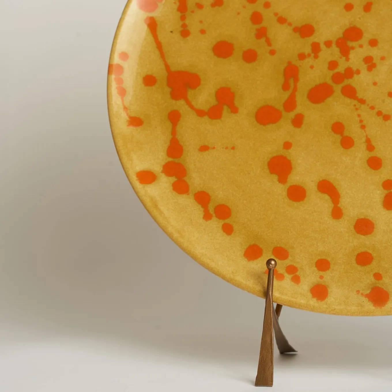 Piatto decorativo in ceramica arancione e caramello