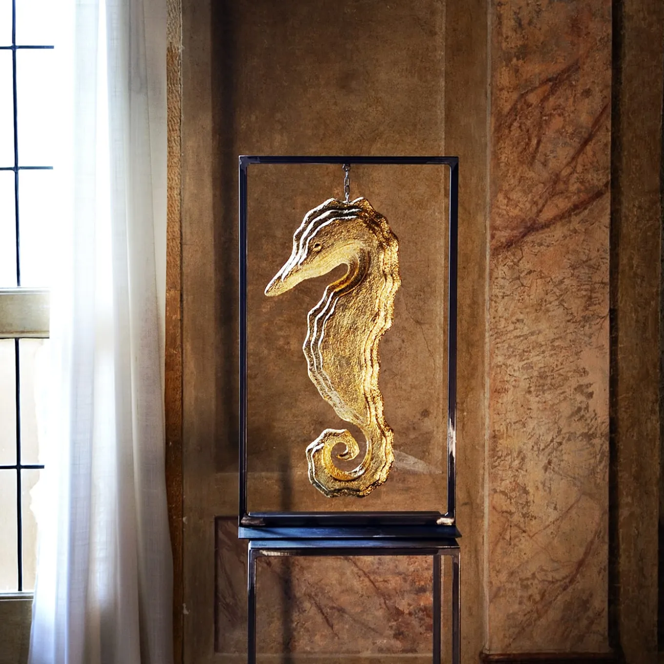 Scultura con cornice in oro a forma di cavalluccio marino